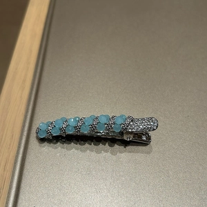 Detail view of silver hair clip with light blue frosted beads and sparkling rhinestones