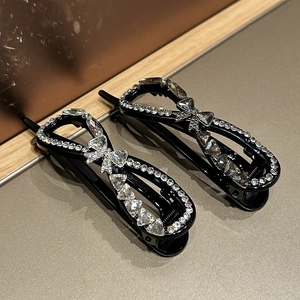Elegant black infinity hair clips set with rhinestones and a delicate central bow design
