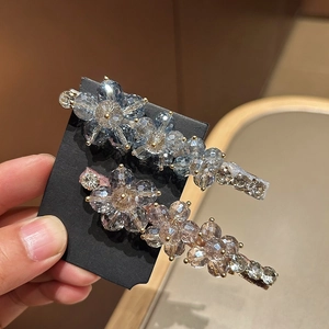 Detailed macro of crystal flower hair clips in light blue and champagne gold finishes