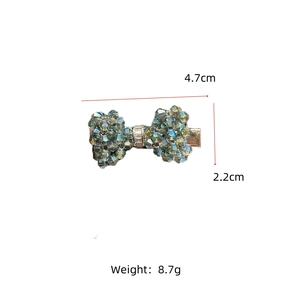 Detailed view of rhinestone bow hair clip showing dimensions of 4.7cm x 2.2cm and teal beads