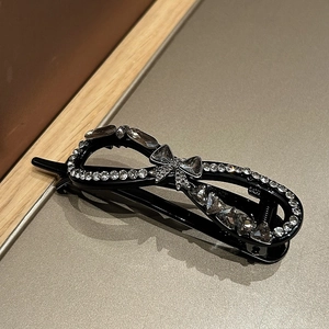 Elegant infinity-shaped hair claw clip with rhinestones and a delicate bow decoration