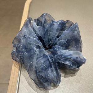 Close-up of navy blue organza scrunchie with shimmering glitter and layered ruffles