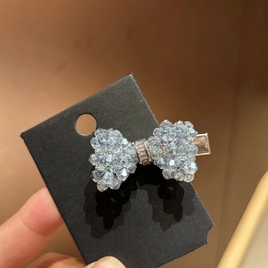 Elegant light blue crystal bow hair clip with silver base on black display card