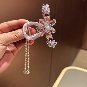 Luxurious pink crystal hair claw clip with elegant pearl tassels and ribbon wrap design