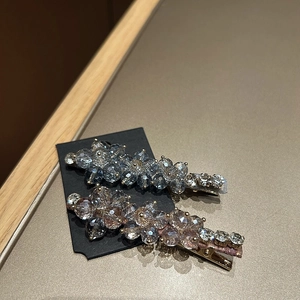 Close-up of floral blue and pink crystal hair clips on a golden metal base