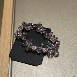 Detail shot of multi-faceted crystal beads in pink and white on a premium hair clip