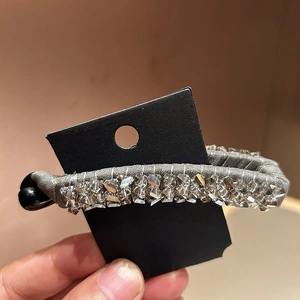 Detailed macro view of silver silk fabric hair clip with sparkling crystal bead accents