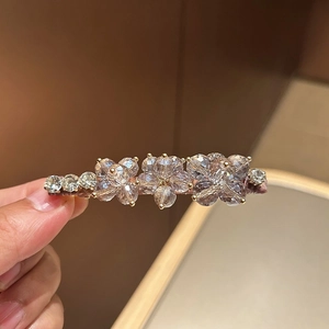 Detail of floral hair clip with blue crystal petals and soft velvet wrap base