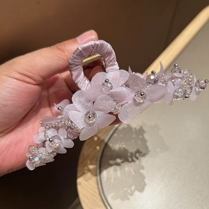 Détail de la pince à cheveux fleurs en tissu violet avec perles de cristal et ruban de soie