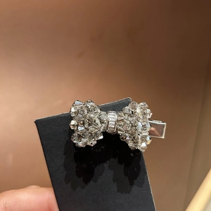 Detail of a sparkling bow-shaped hair clip with crystals and silver metal base