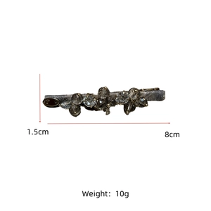 Detailed view of an 8cm crystal duckbill hair clip with beads on a grey fabric base