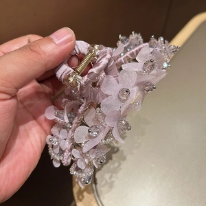 Détail de la pince à cheveux fleur violette en soie avec cristaux et ressort doré