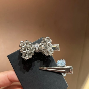 Detailed macro view of crystal bow hair clips with silver metal duckbill base