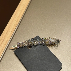 Macro shot of elegant gold hair clip featuring colorful crystals and faceted beads