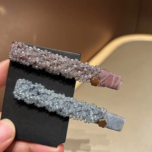 Détail de pinces à cheveux à perles de cristal roses et bleues avec fleurs dorées