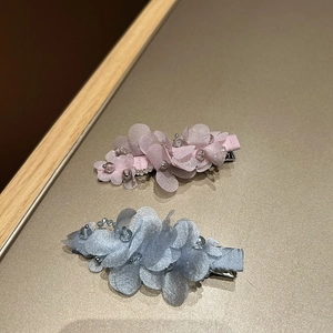 Vue détaillée de barrettes fleurs en tissu faites main avec perles de cristal en rose et bleu