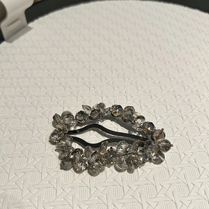 Detail of handmade crystal hair clip featuring grey faceted beads and metallic base