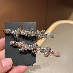 Detail view of crystal hair clips with sparkling stones and pink fabric texture