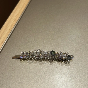 Macro shot of silver hair clip featuring ice blue and grey faceted crystal beads