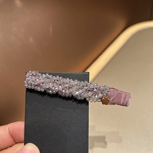 Détail d'une barrette à cheveux en perles de cristal rose avec fleur dorée