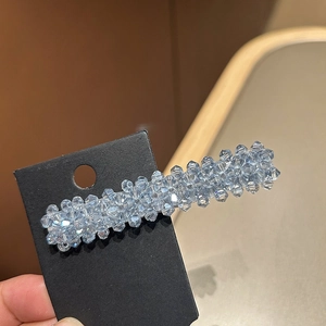 Barrette à cheveux en cristal bleu clair avec perles facettées tenue à la main sur carte