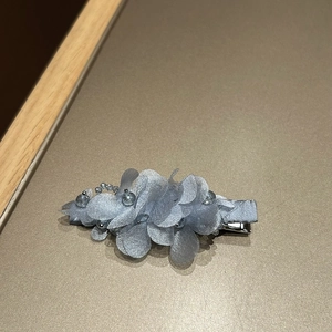 Détail de la pince à cheveux avec fleurs en maille de cristal bleu et pétales multicouches