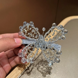 Detailed view of handcrafted light blue crystal beaded butterfly hair clip with gold wire
