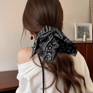 Detail of navy blue vintage paisley pattern bow scrunchie on a ponytail hair style