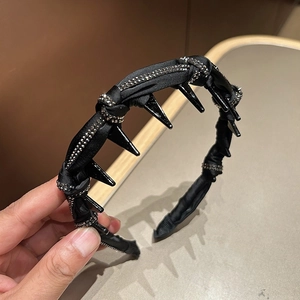 Detailed view of black satin headband with silver rhinestones and integrated hair claw clips