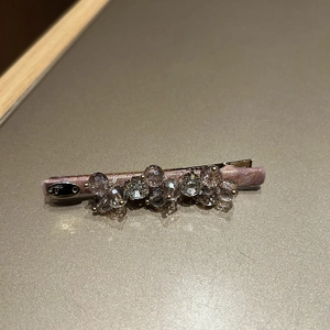 Detailed macro view of crystal hair clip with lavender rhinestones and silk lining