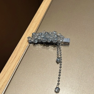 Dettaglio del fermaglio per capelli con perle di cristallo azzurro e nappe pendenti
