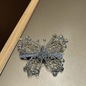 Detail of handcrafted blue crystal beaded butterfly hair clip with gold wire weaving