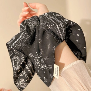 Detail of navy blue bandana print scrunchie with long ribbons and handmade label tag