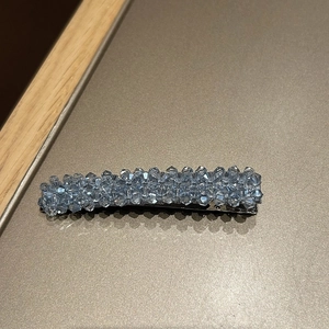 Détail macro de perles de cristal bleu clair facettées tissées sur un clip en métal argent