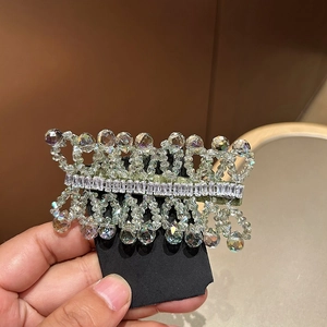 Detailed macro of crystal hair clip with teardrop pendants and baguette zircon stones