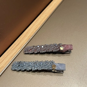 Détail de barrettes faites à la main avec cristaux facettés et fleurs dorées