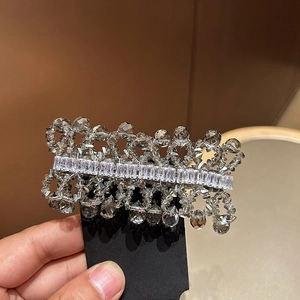 Close-up of handmade woven crystal hair clip with rectangular zircons on black card