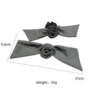 Detail view of gray striped fabric rose hair clip and tie with 31cm length dimensions