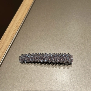 Vue détaillée d'une barrette à cheveux faite main avec cristaux violets sur clip en métal