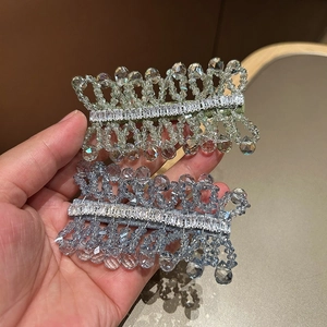 Detail of handcrafted crystal beaded hair clips with sparkling zircon stones in blue and green