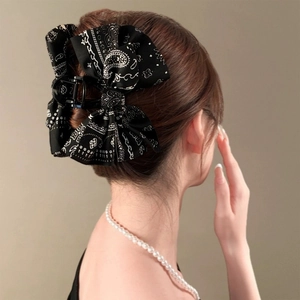 Detail of black bandana print bow hair claw clip showing fabric texture and firm grip