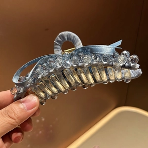 Detail of light blue ribbon hair claw clip with sparkling clear beaded crystal accents