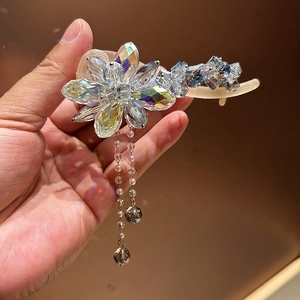Détail macro de la pince à cheveux fleur en cristal avec perles et accents bleus