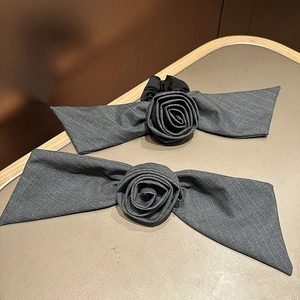 Detail of grey striped fabric hair ties with fabric roses and long ribbons