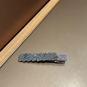 Détail d'une pince à cheveux en perles de cristal bleu clair avec fleur dorée