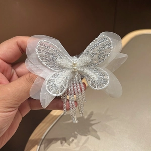 Barrette papillon élégante en maille blanche avec pompons en perles et paillettes argentées