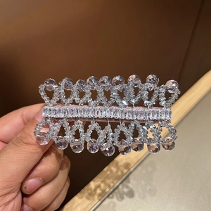 Detail of handcrafted crystal hair clip with sparkling zircon stones on pink base