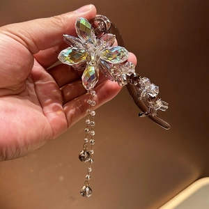 Pince à cheveux fleurie avec cristaux, pompons en perles et détails de pierres irisées