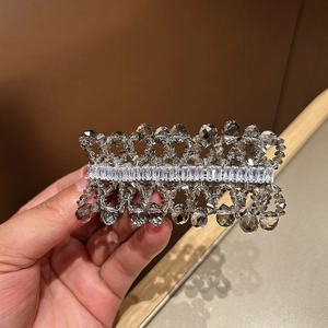 Detailed close-up of handmade crystal hair clip with smoky grey beads and zircon stones