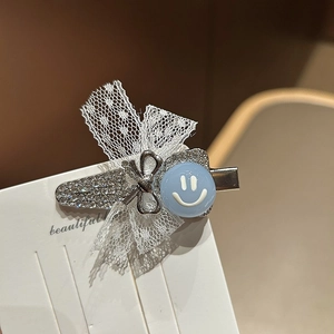 Fermaglio blu con faccina sorridente fiocco in pizzo bianco e strass brillanti
